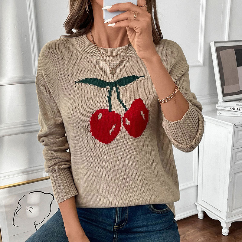 Women's oversized knit sweater with cherry intarsia, lightly distressed look and round neck.