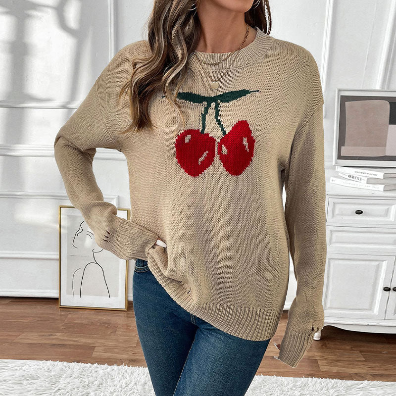 Women's oversized knit sweater with cherry intarsia, lightly distressed look and round neck.