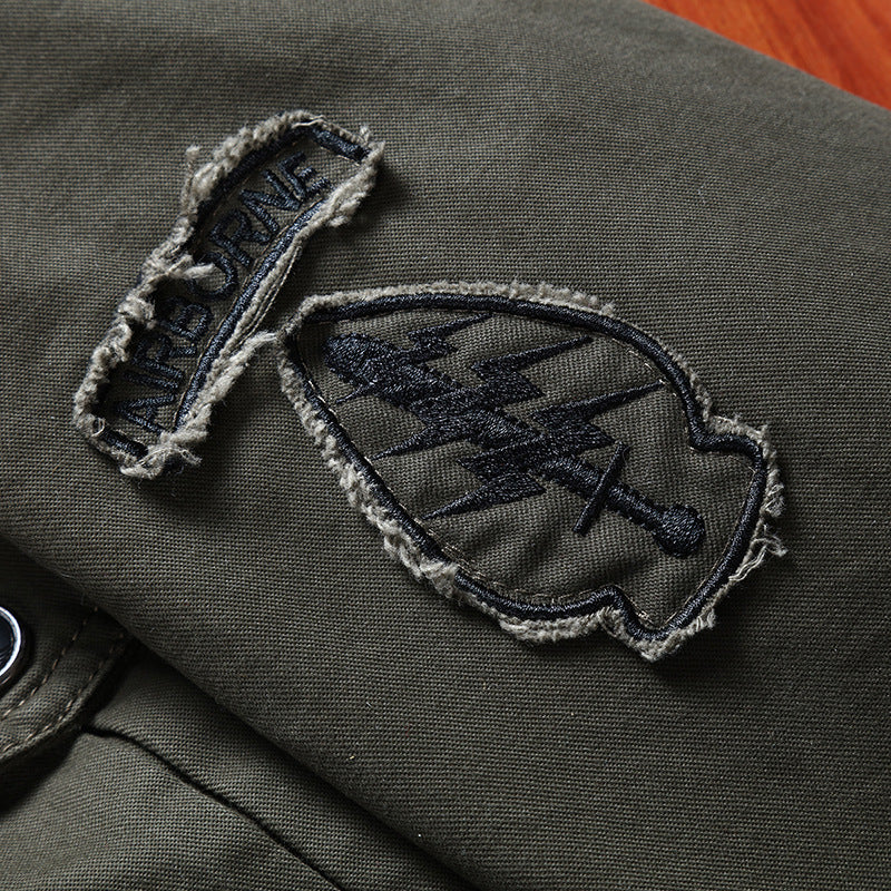 Men's canvas field jacket in military utility style with stand-up collar, shoulder patches, and multi-functional pockets Chichicherry