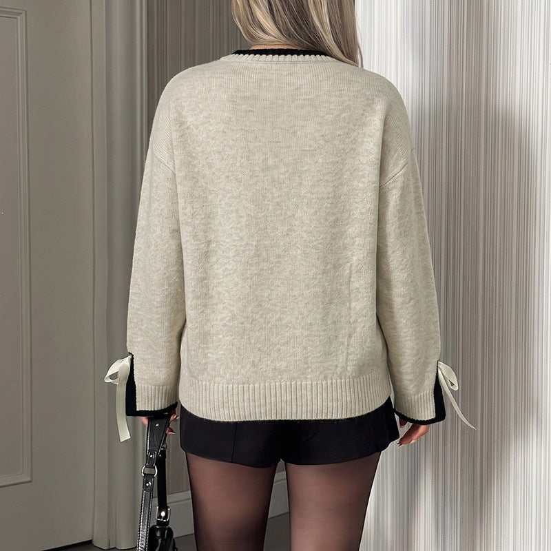 Women's oversized fine knit pullover with contrast ribbed yoke and bow details