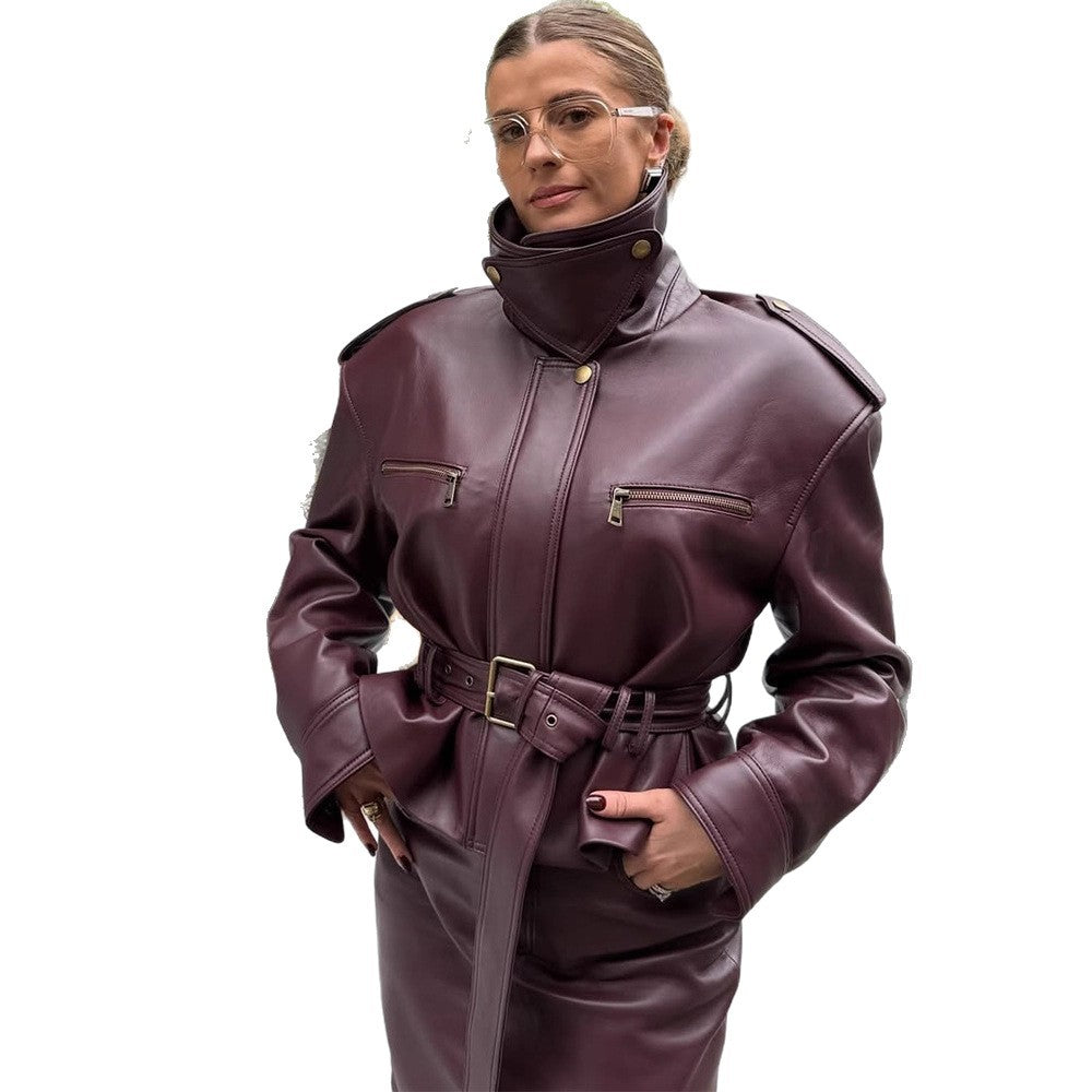 Women's short jacket made of faux leather with a high stand-up collar, fitted tie belt, and prominent shoulder pads Chichicherry
