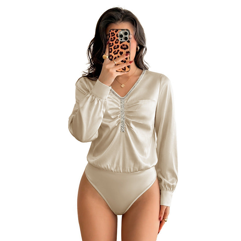 Women's satin blouse with V-neck, gathered front section and decorative ribbon.