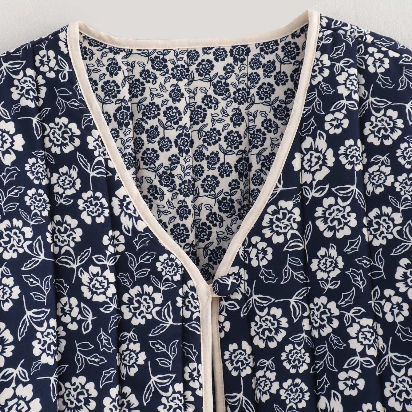 Ladies quilted jacket with floral allover, V-neck, contrast piping and patch pockets Chichicherry