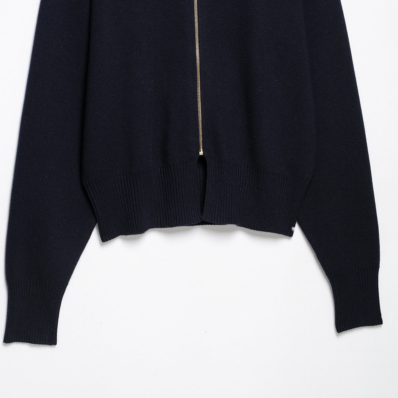 Women's cropped fine-knit cardigan with standing collar, full-length zipper, and fitted ribbed section.