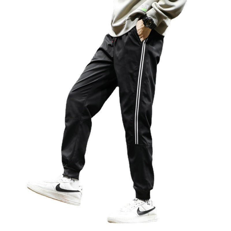 Men's sporty jogging pants in track style with side contrast stripes, drawstring, and elastic cuffs.