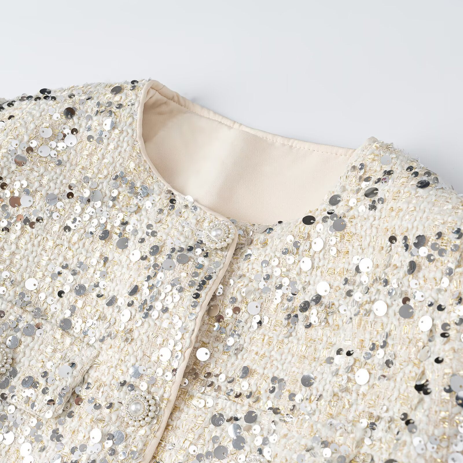 Women's short jacket made of bouclé with sequin trim, decorative pearl buttons, and a belted waist Chichicherry
