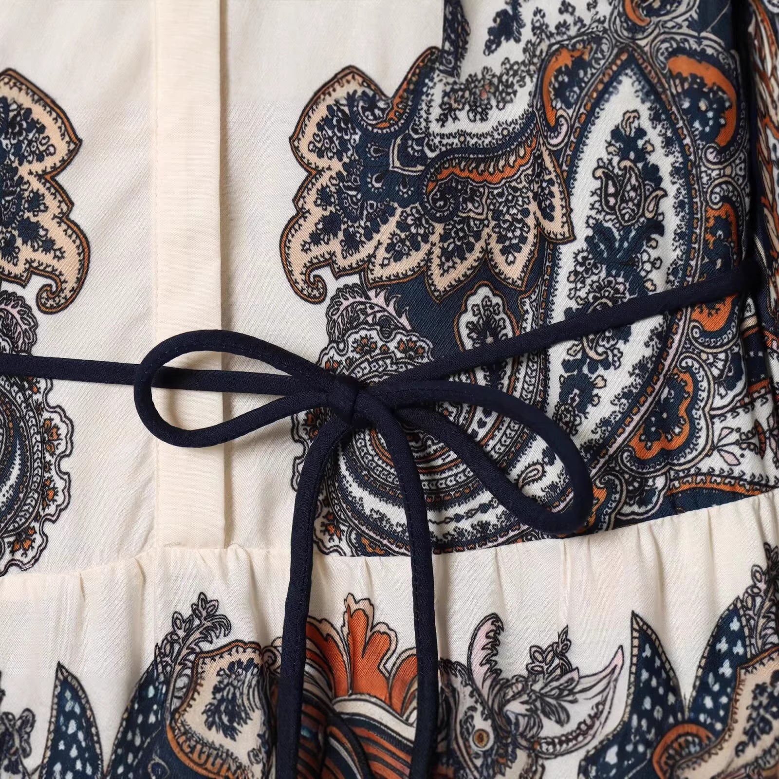 Women's maxi dress in tiered skirt design with paisley print, stand collar, and waist drawstring Chichicherry