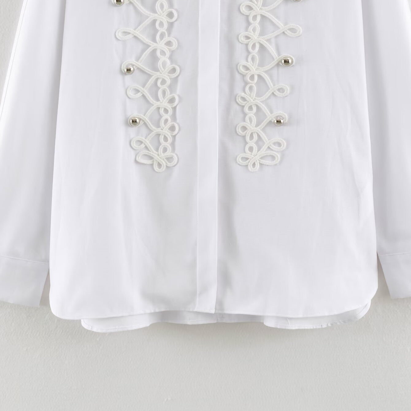 Women's blouse with long sleeves and decorative frog jewelry as well as concealed button placket
