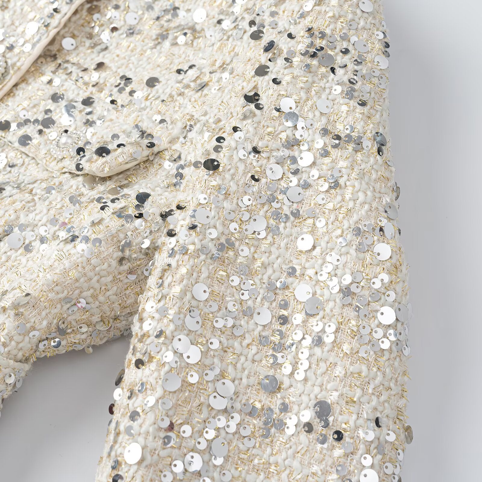 Women's short jacket made of bouclé with sequin trim, decorative pearl buttons, and a belted waist Chichicherry