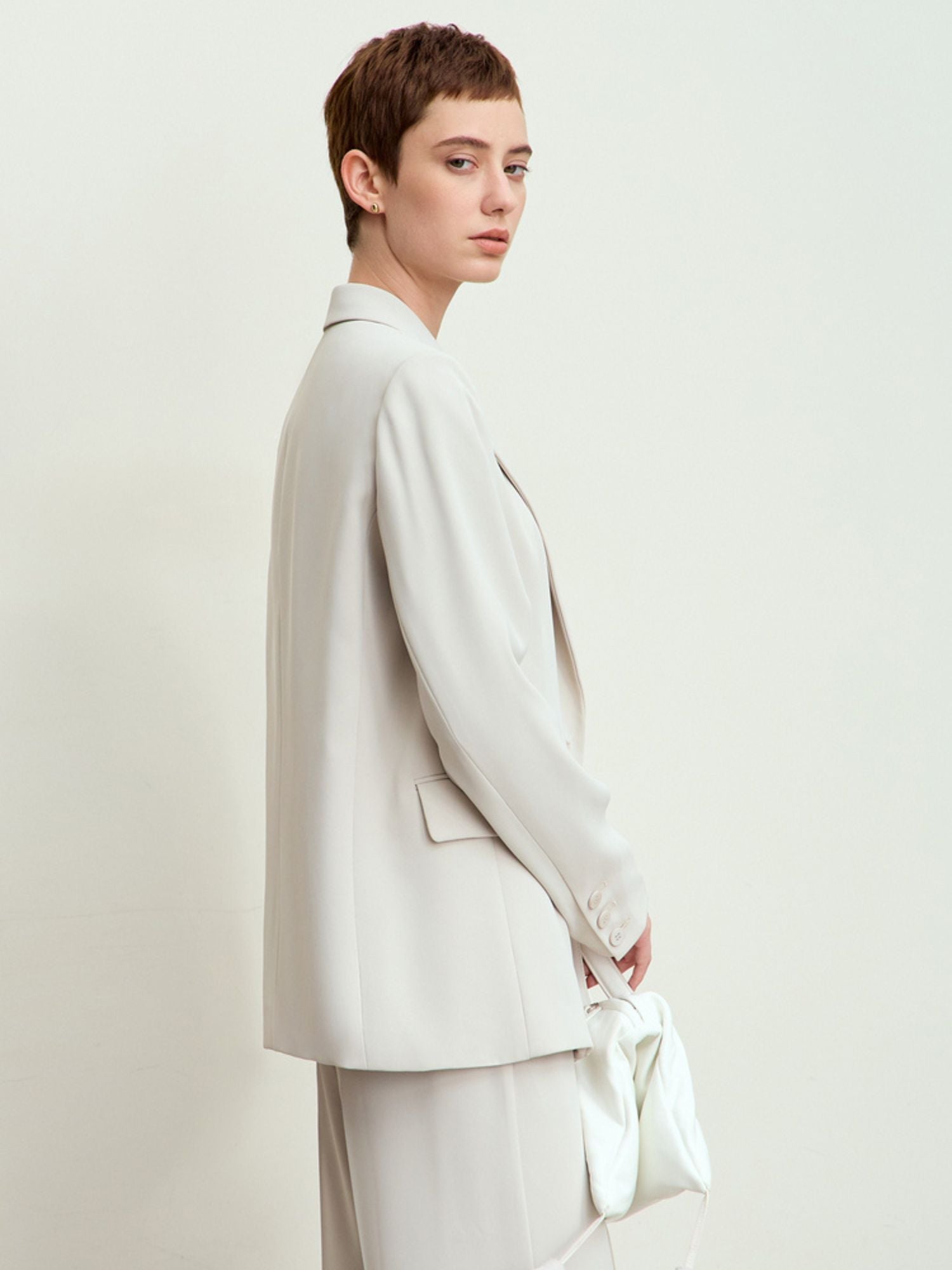 Three-quarter side/back view of blazer paired with matching trousers