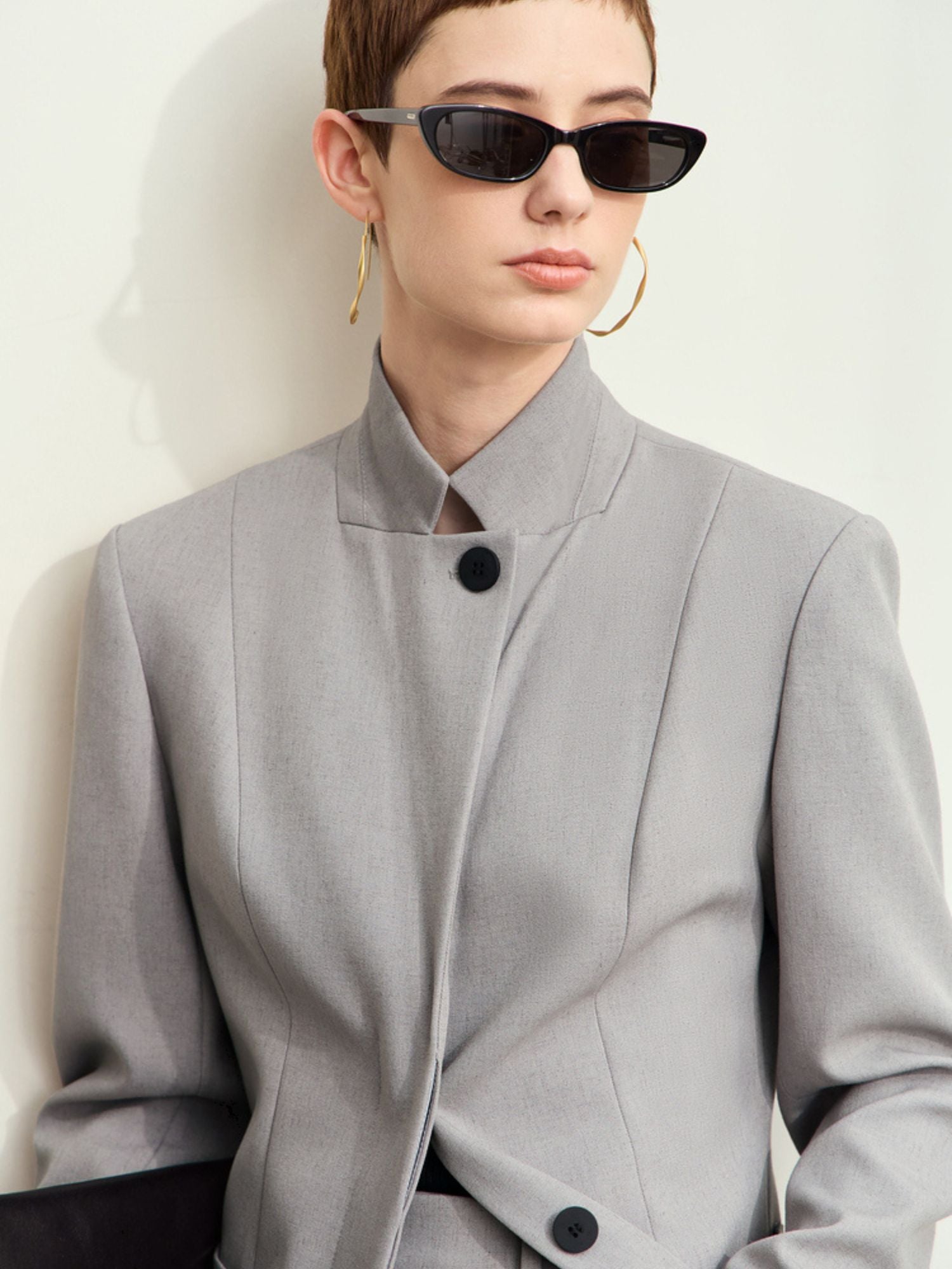 Close-up of two dark buttons on light-grey blazer sleeve