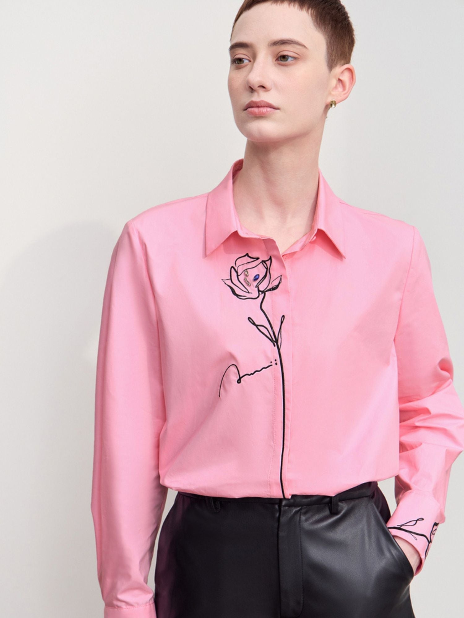 Front close-up of pink shirt highlighting rose embroidery and button closure