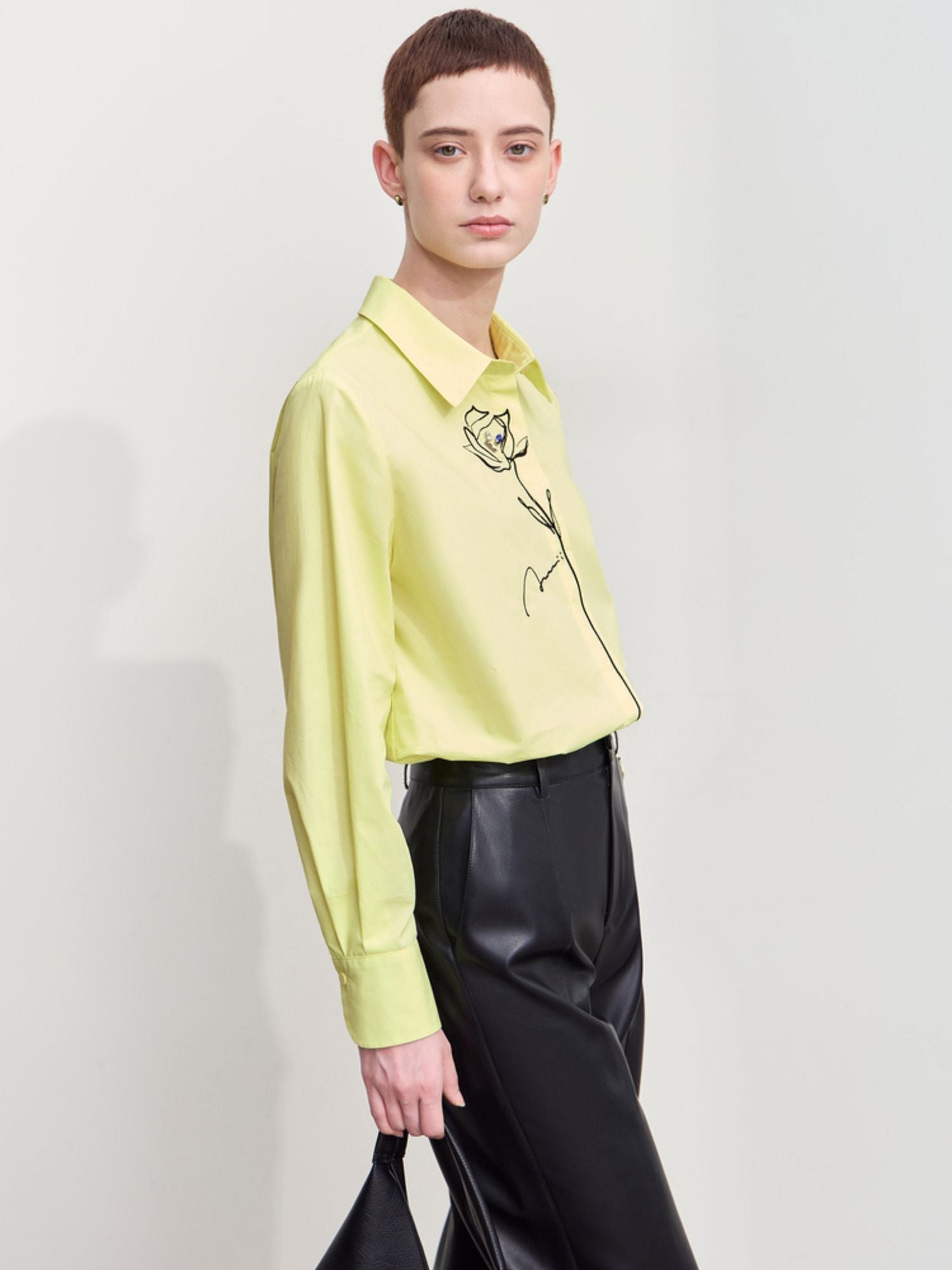 Three‑quarter front view of yellow embroidered shirt showing relaxed fit