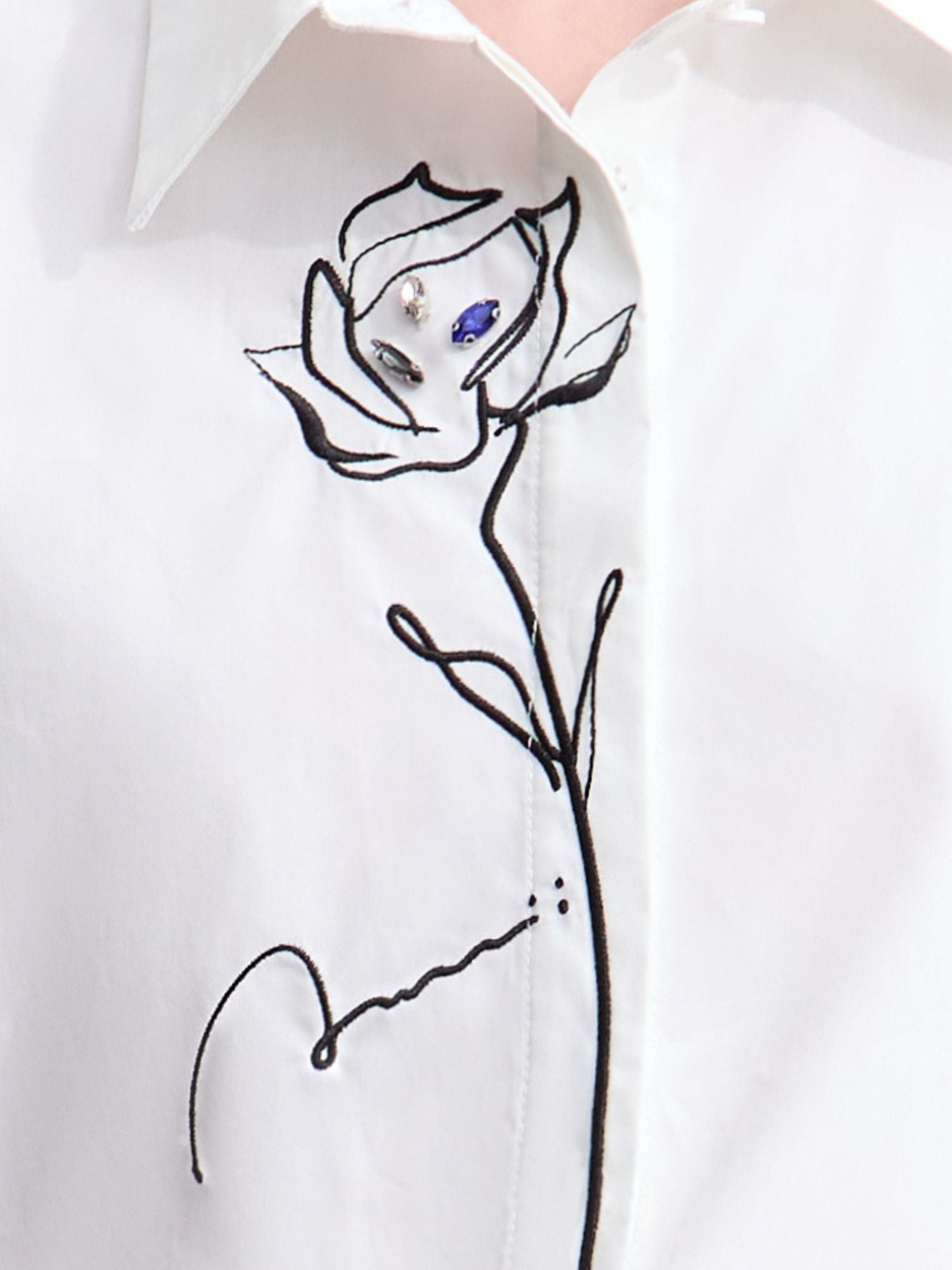 Close-up of shirt’s front showing embroidered rose detail and collar