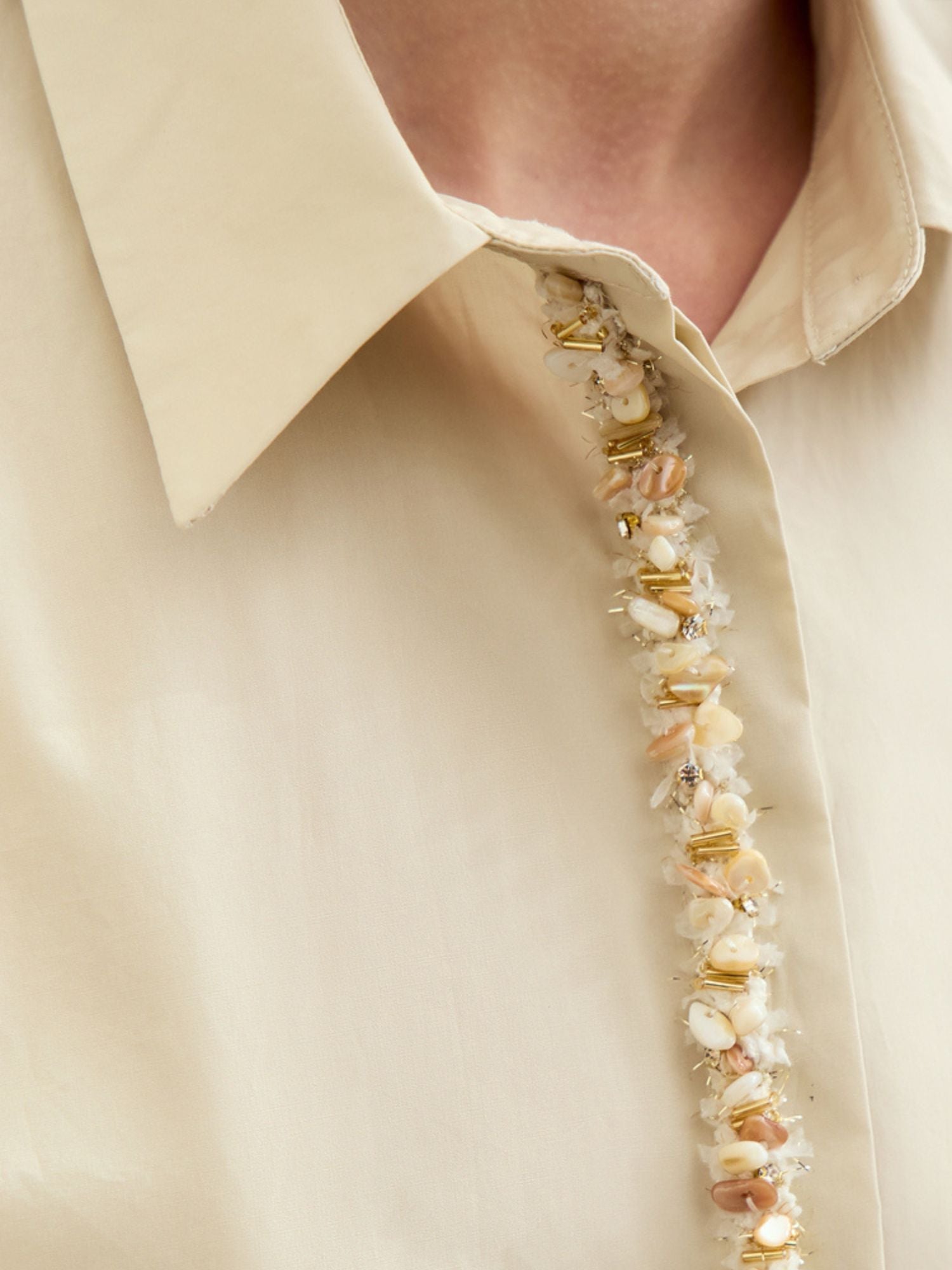 Close-up of beige long sleeves blouse front details 