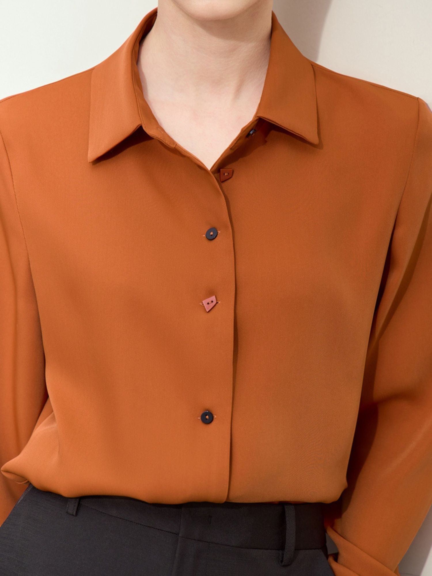 Close-up of rust blouse front showing collar and top button detail