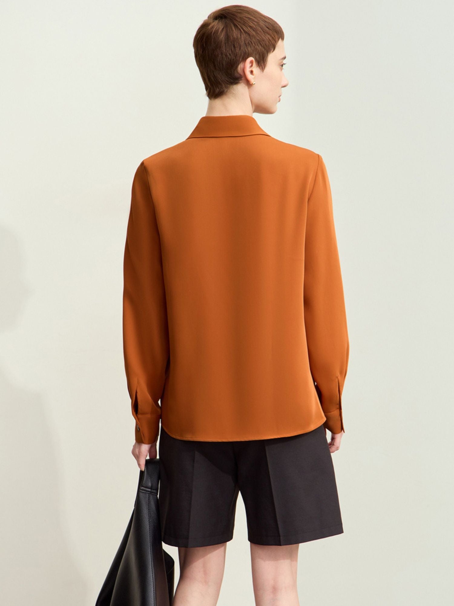 Rear view of rust blouse with pointed collar and relaxed hemline