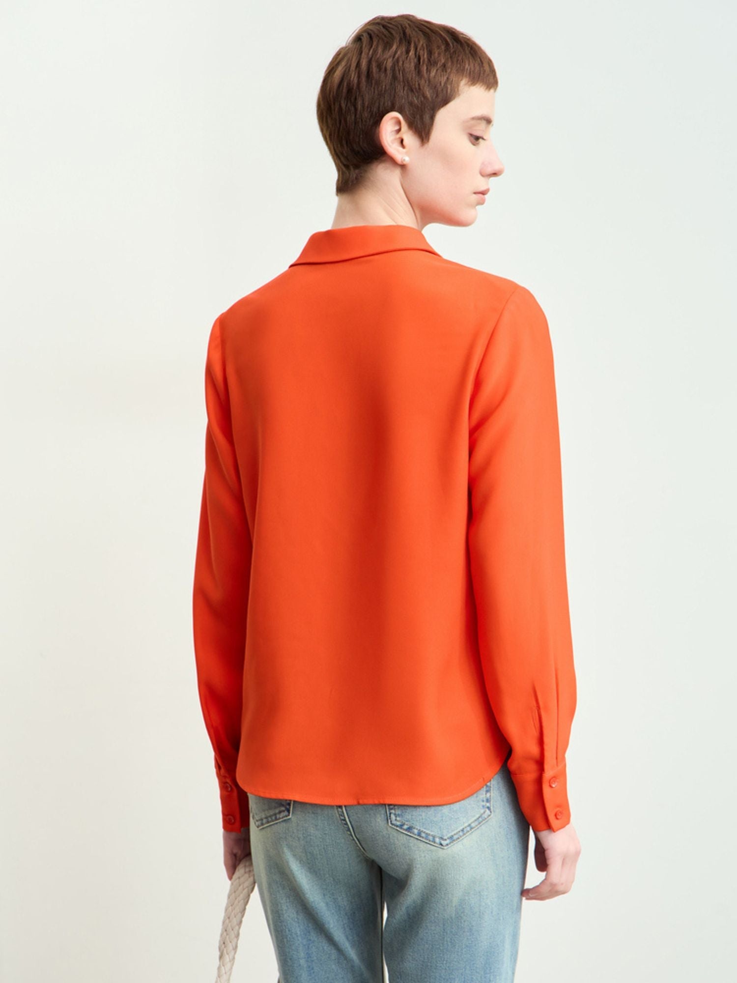 Back view of rust-orange blouse with clean hemline
