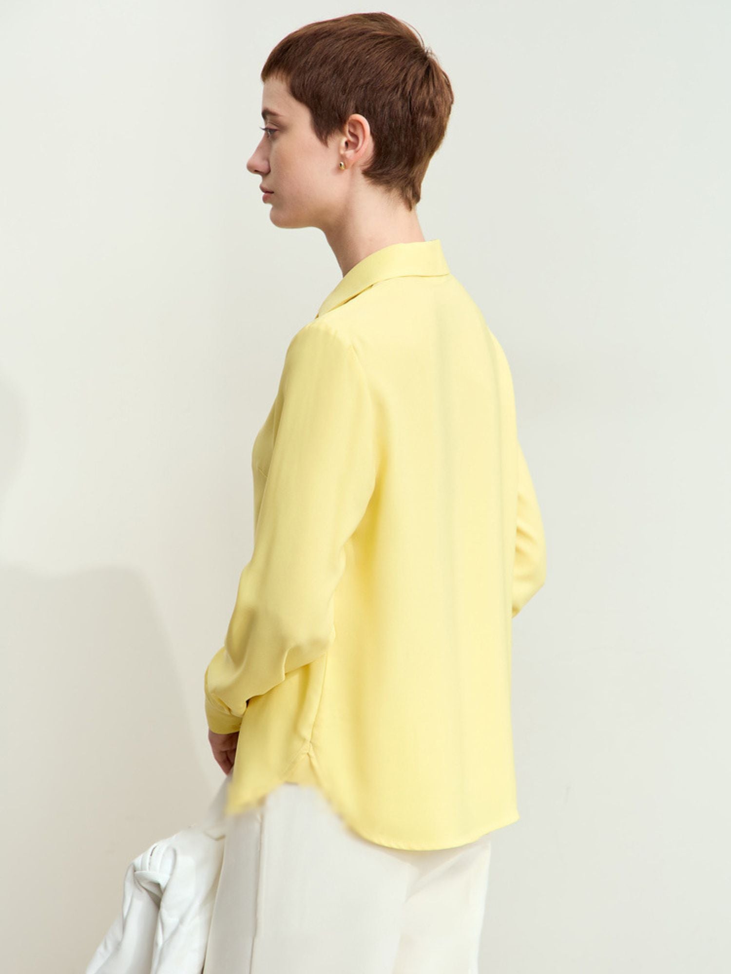 Three-quarter side view of yellow blouse highlighting sleeve cut and relaxed fit