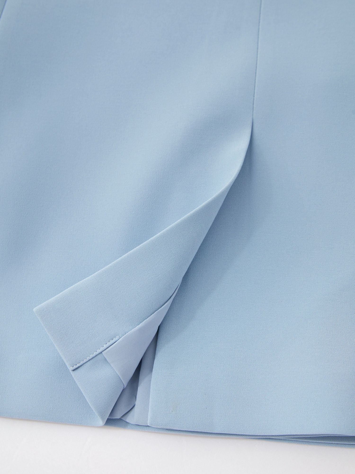 Close-up of light blue blazer highlighting back seam and vent
