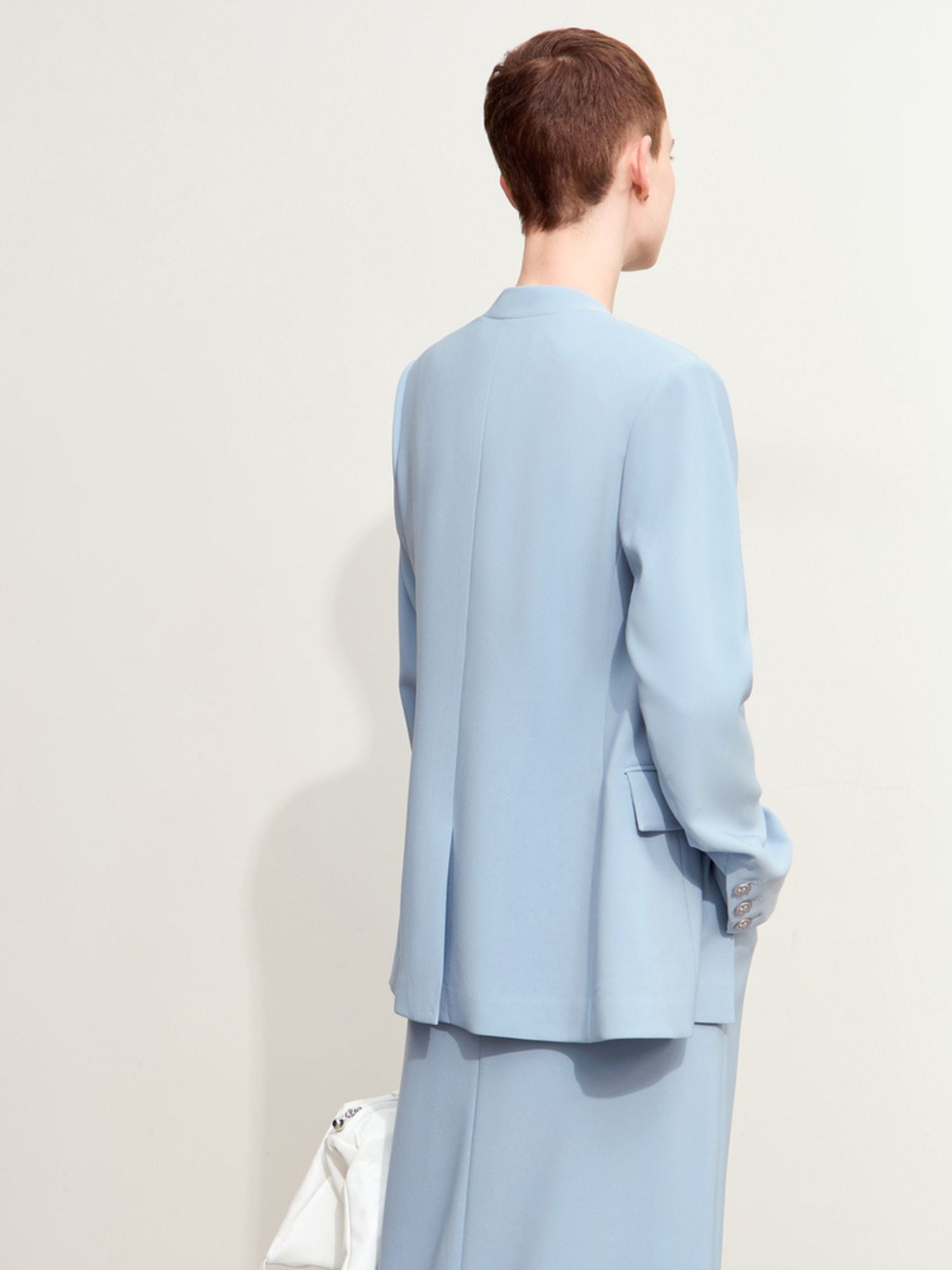Back view of the light blue blazer showcasing center seam and vent