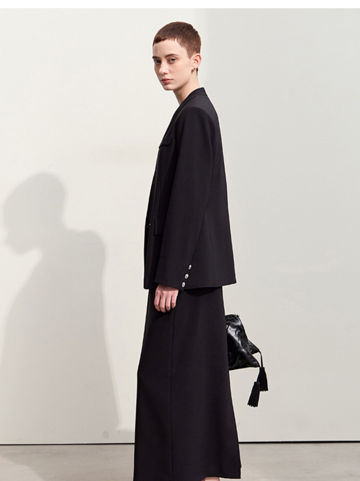 Side view of the black blazer highlighting its relaxed silhouette