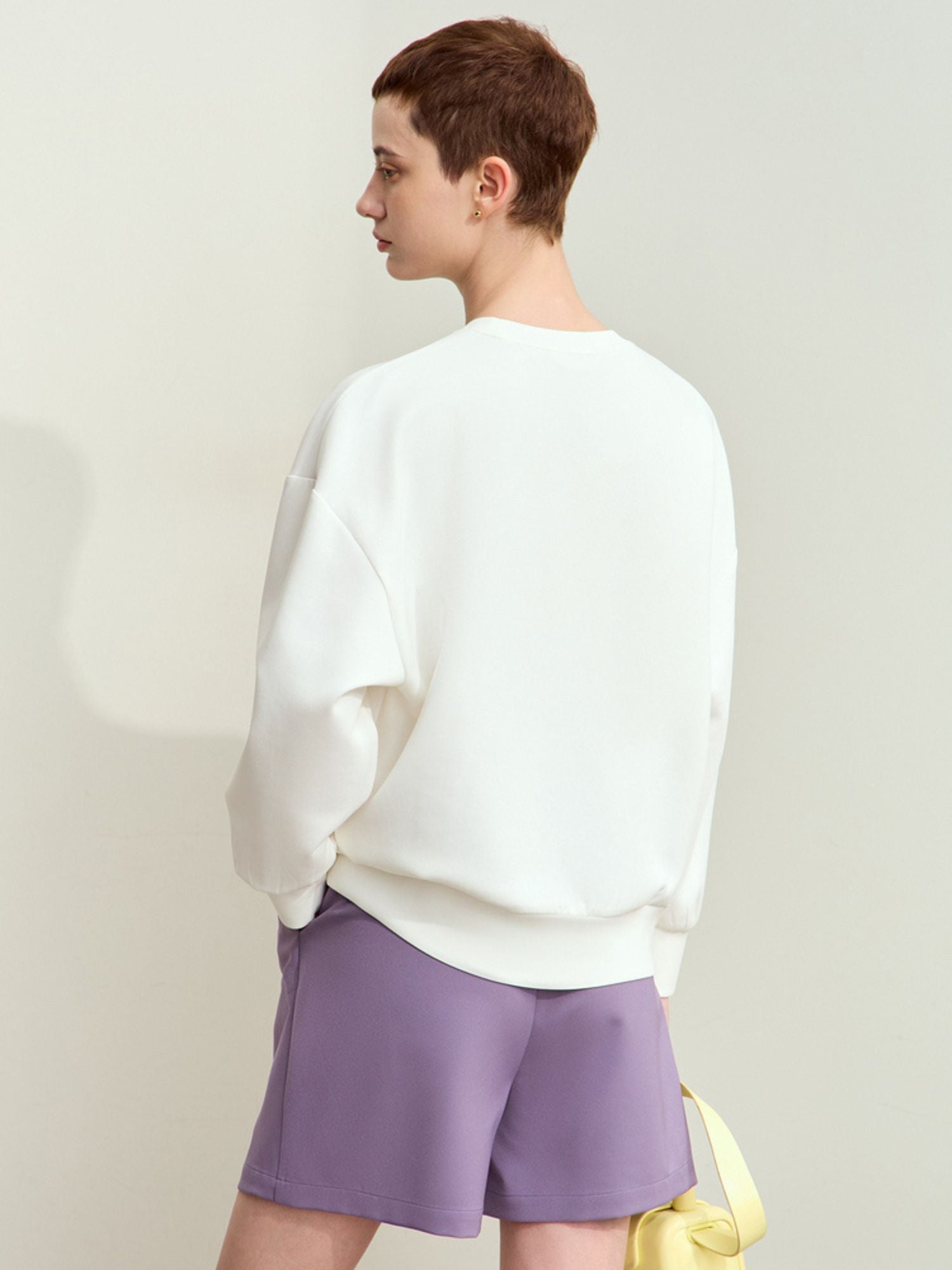 Back view of white graphic sweatshirt showcasing simple cut and back fit