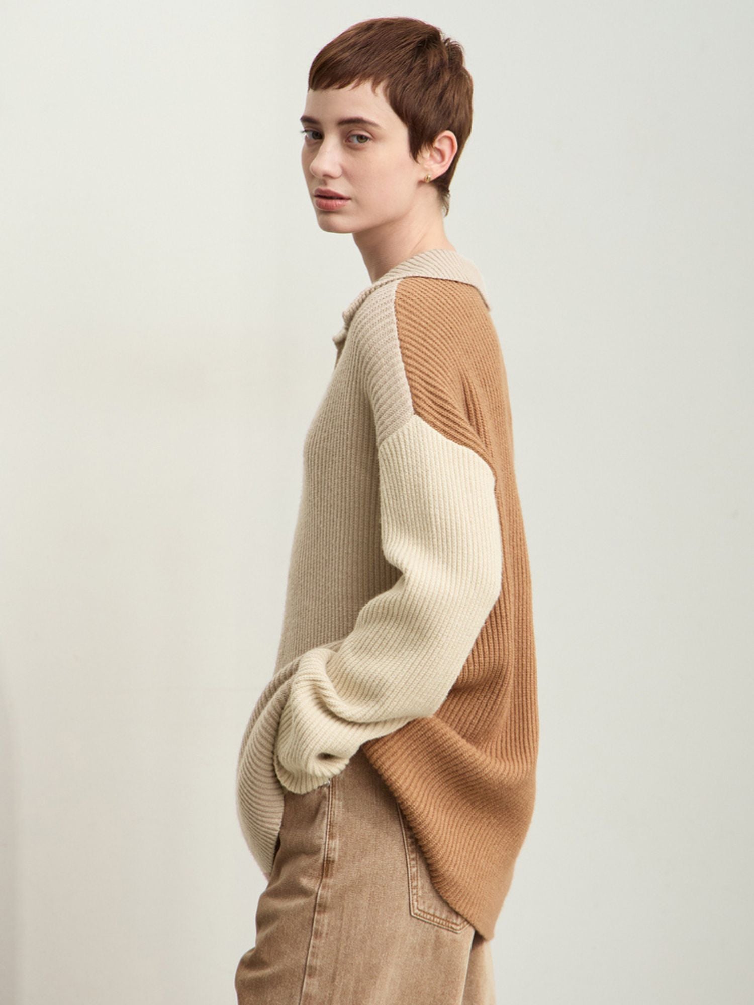 Three-quarter side view of beige/cream sweater showing draped silhouette