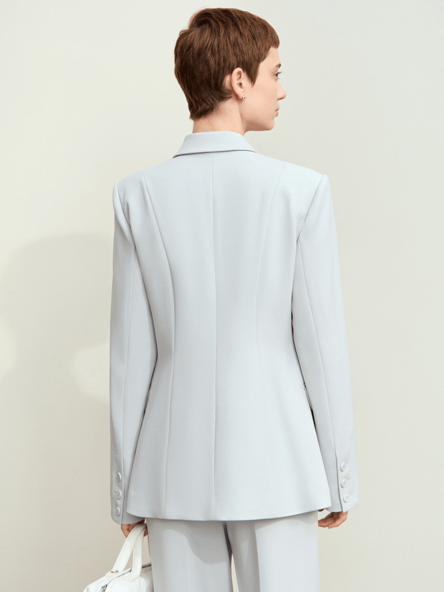 Back view of light‑blue blazer showcasing center vent and structured fit