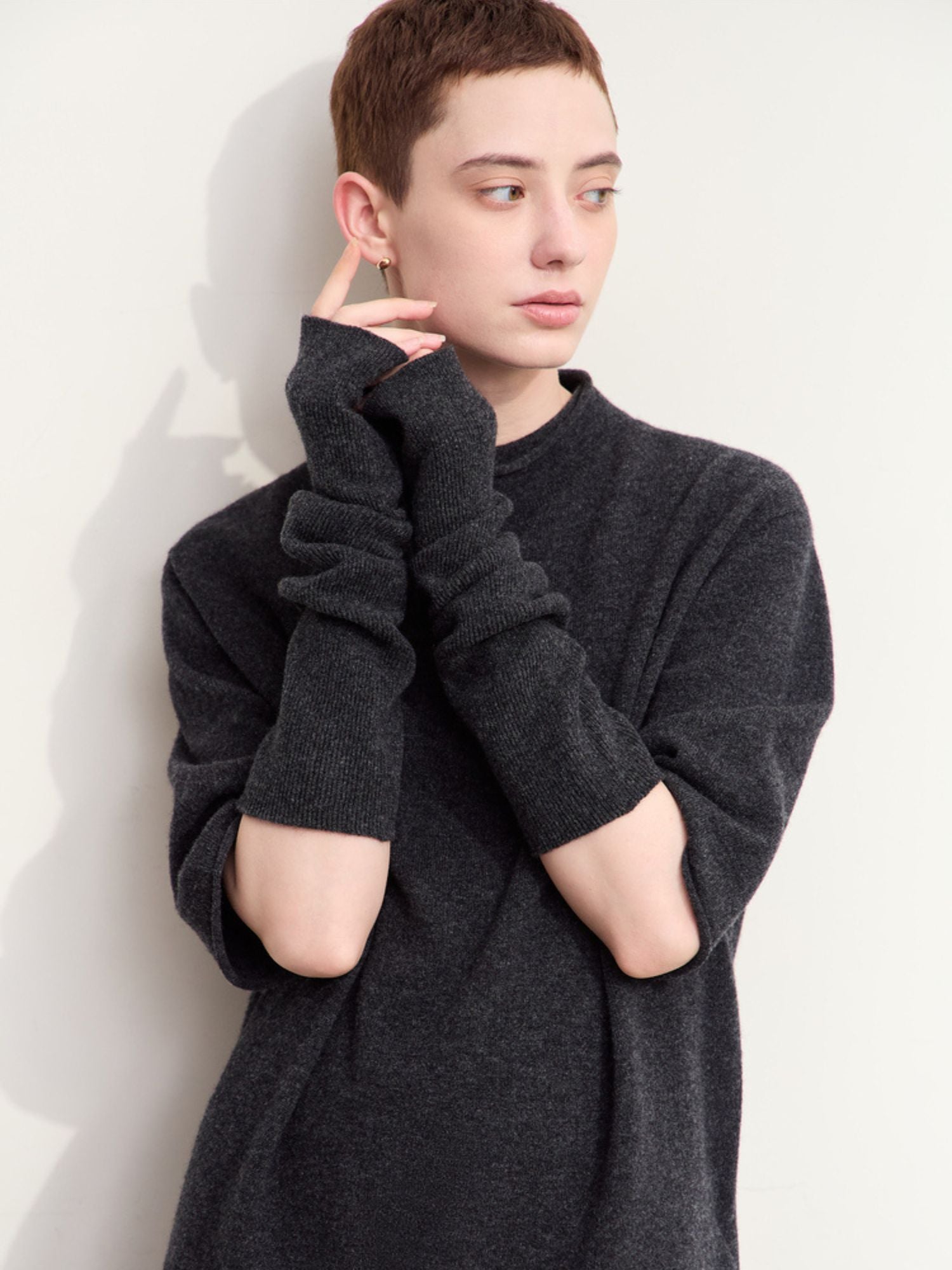 Rear three-quarter view of charcoal grey sweater and skirt showing fit and sleeve detail