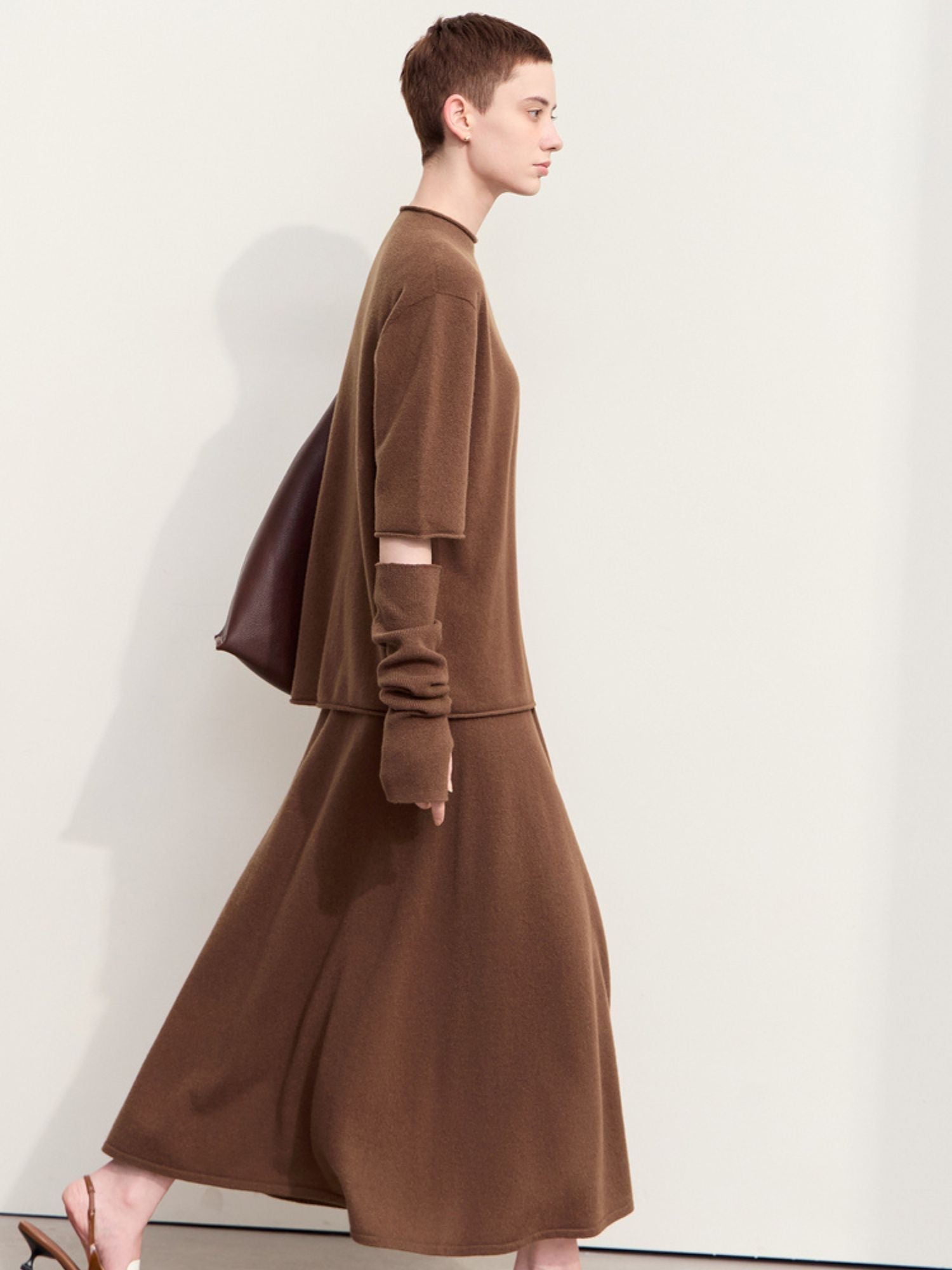 Rear three-quarter view of oversized brown sweater and skirt highlighting side slit
