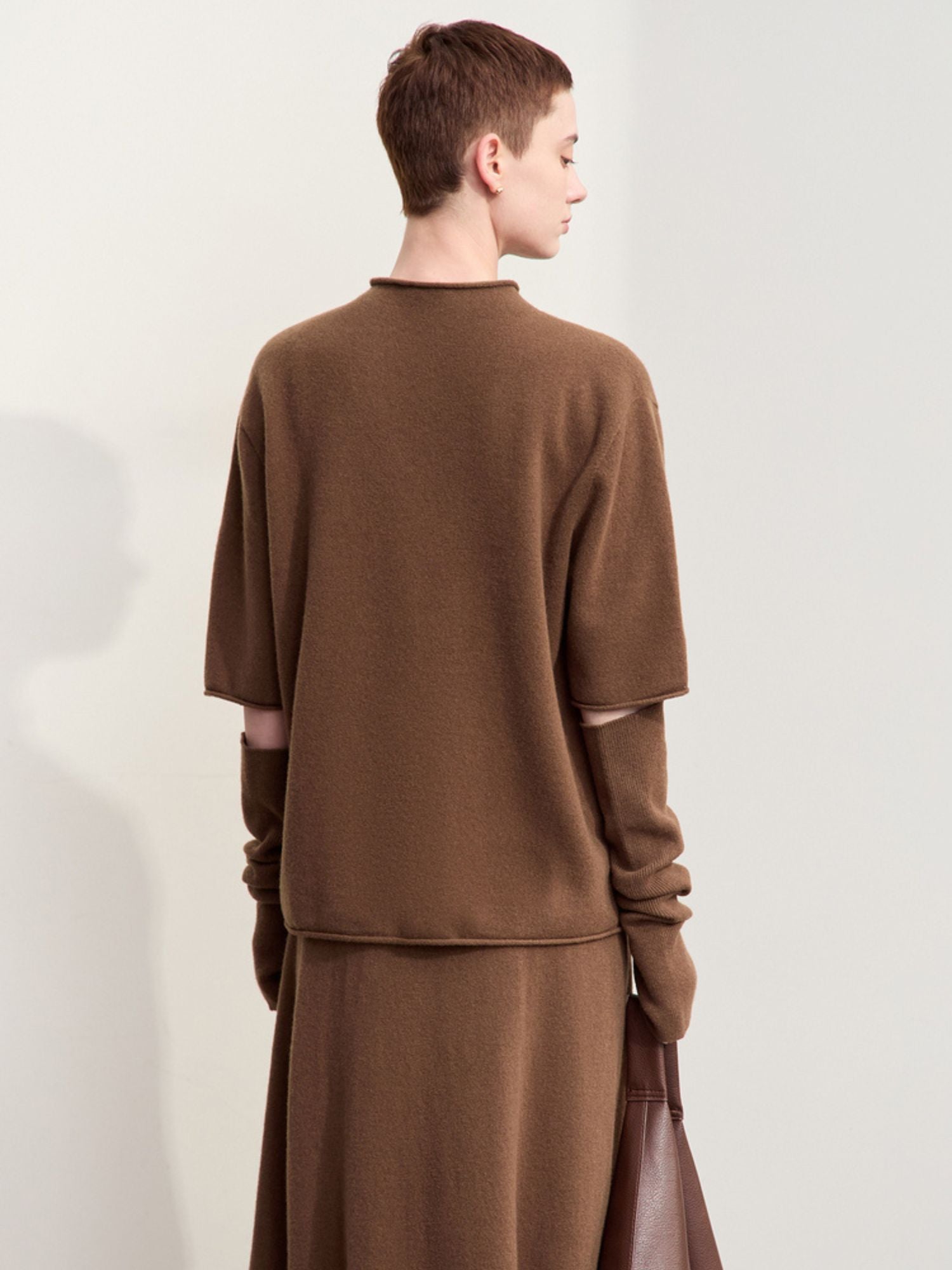 Back view of oversized brown sweater showing relaxed drape and hem