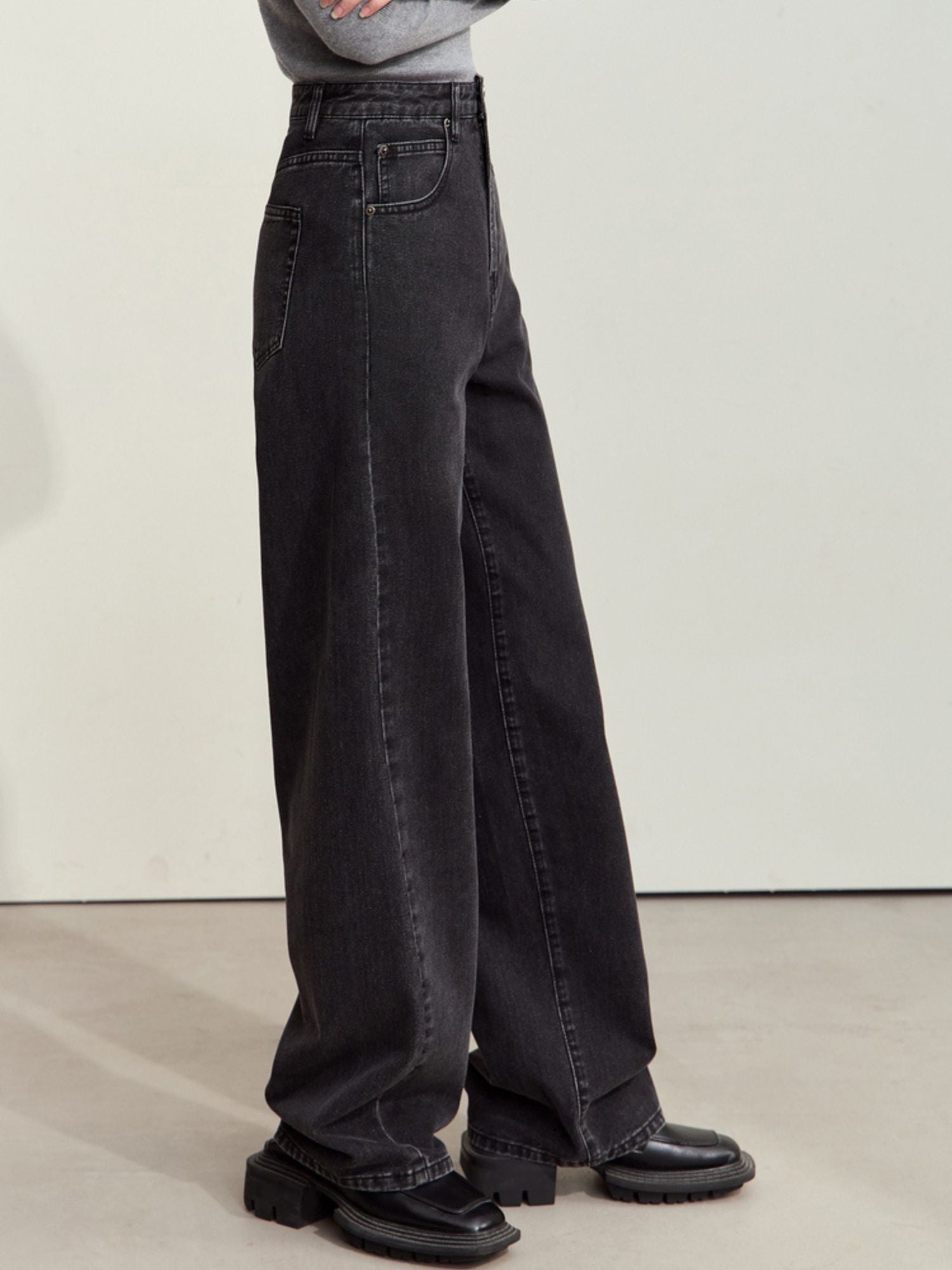 Side view of black corduroy pants, showing relaxed fit and high waist