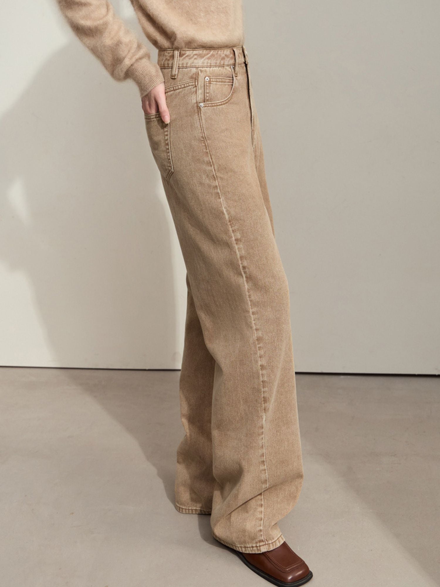 Side view of wide-leg tan corduroy pants, showing movement and relaxed fit
