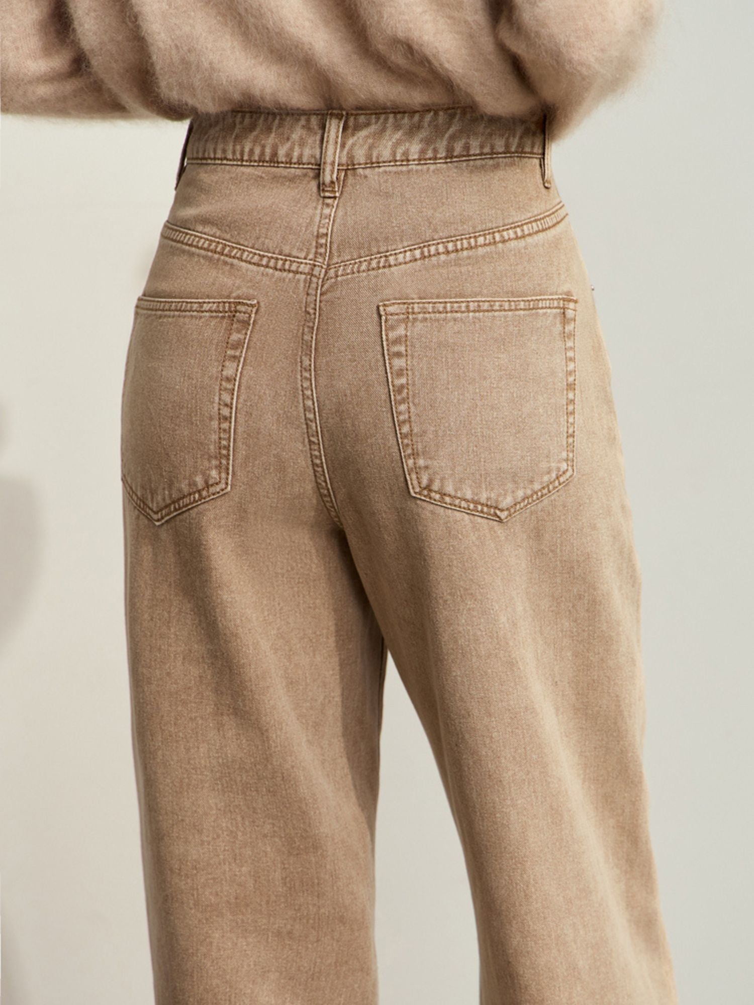 Close-up back view of tan corduroy pants, highlighting the back pockets and stitching detail